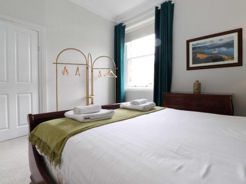 a bedroom with a large white bed with towels on it at Cameron Fell Apartment Keswick in Keswick