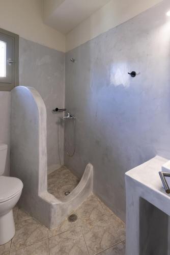 a bathroom with a shower with a toilet and a sink at Bells Rooms and Suites in Ermoupoli