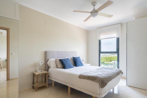 1 dormitorio blanco con 1 cama y ventilador de techo en Magnifico apartamento en Canet Playa by Hometels, en Canet de Berenguer