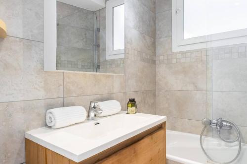 een badkamer met een witte wastafel en een douche bij Le Voeu - Appartement avec vue sur Nice in Nice