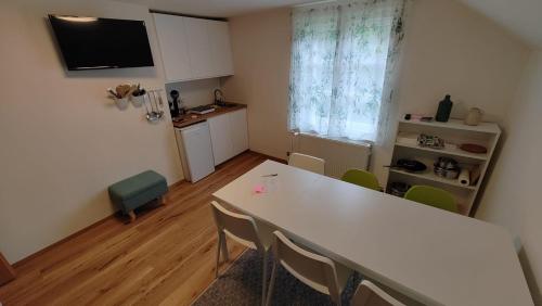 a dining room with a white table and chairs at Fuchsbauerhof - Ferienwohnung in Kniezenberg
