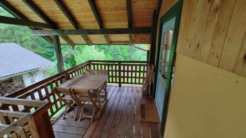 a wooden deck with a table and chairs on it at Fuchsbauerhof - Ferienwohnung in Kniezenberg