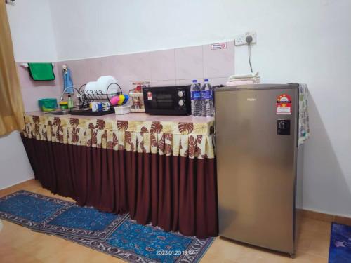 Il comprend une cuisine équipée d'une table et d'un réfrigérateur. dans l'établissement Inapan desa bukit papan, à Kuala Perlis