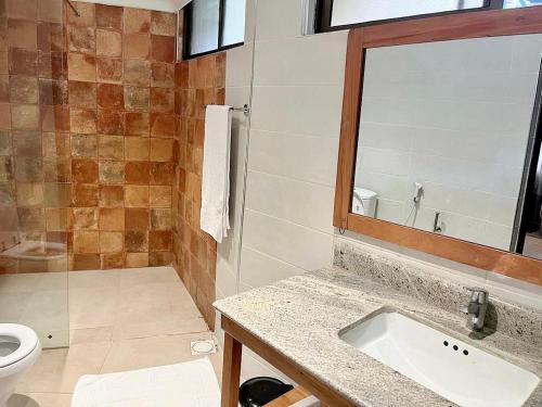 a bathroom with a sink and a toilet and a mirror at Morogoro Hotel in Morogoro