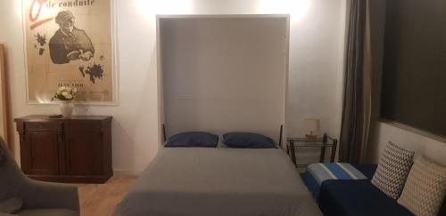 um pequeno quarto com uma cama e um sofá em Charming Loft - Tour Eiffel/ Rue Cler em Paris