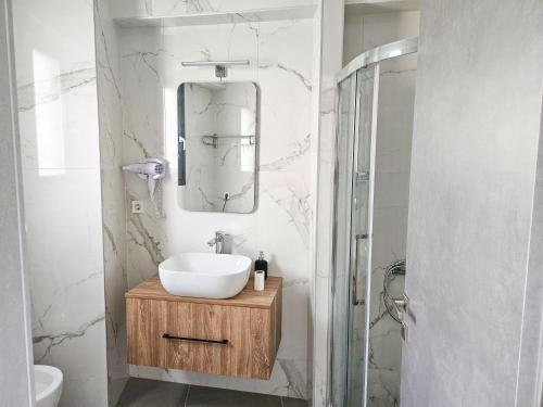 ein Bad mit einem Waschbecken und einem Spiegel in der Unterkunft Andes Apartments in Ioannina