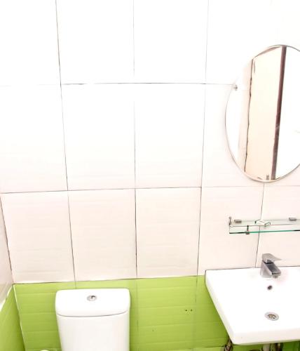 a bathroom with a sink and a toilet and a mirror at Hotel SV International in Kodaikānāl