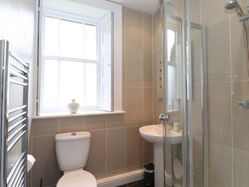 a bathroom with a toilet and a sink and a window at Bethby Beck Apartment Keswick at The Lairbeck in Keswick