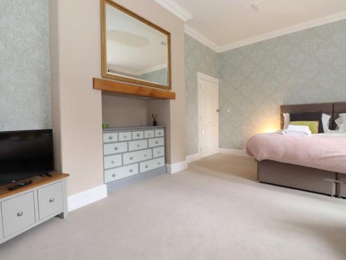 a bedroom with a bed and a mirror and a television at Bethby Beck Apartment Keswick in Keswick