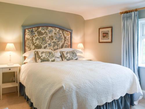 a bedroom with a large white bed and a window at Club Cottage in Dummer