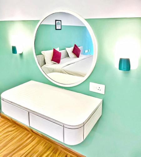 a circular mirror above a bed in a room at Hotel SV International in Kodaikānāl
