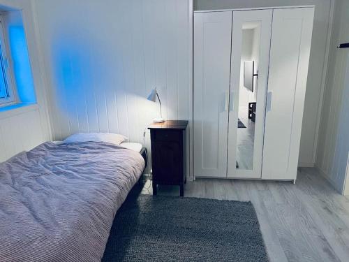 a bedroom with a bed and a table and a mirror at Holiday home with sauna in the Arctic Caribbean, Tromsø in Tromsø