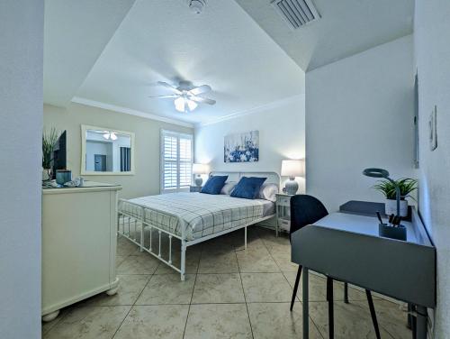 a bedroom with a bed and a table and a couch at 2 Bed-1 Bath With Sunroom, Private Pool And Beach Access! in Clearwater Beach