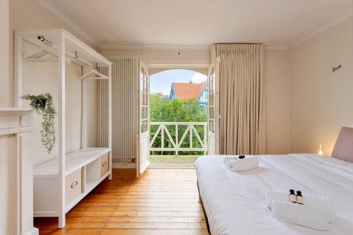 een slaapkamer met een groot bed en een groot raam bij Villa Pauline in De Panne