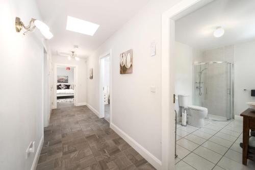 a white bathroom with a shower and a toilet at Cottage 345 - Oughterard in Oughterard