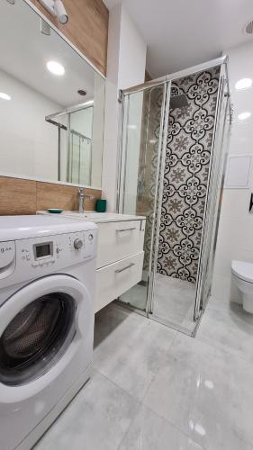 uma máquina de lavar roupa na casa de banho com um chuveiro em Silver Apartments - Orientarium,Aquapark Fala & Park em Lódź