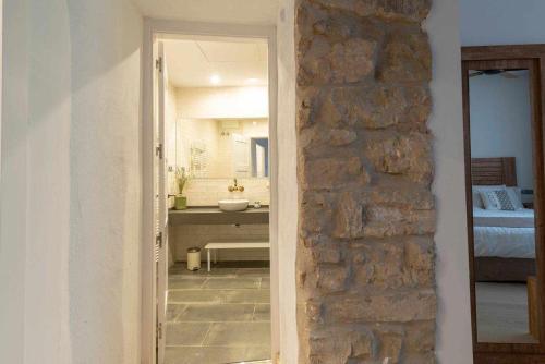 una puerta de acceso a un baño con una pared de piedra en Casa de ensueño en Almatret, en Riba-roja d'Ebre