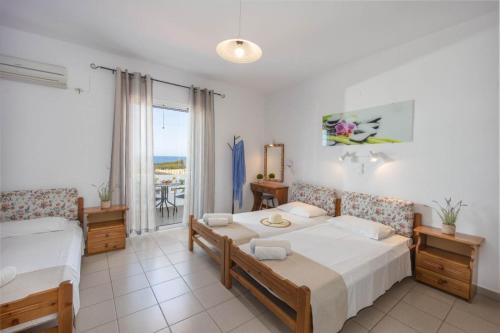 Schlafzimmer mit einem Bett und einem Fenster mit Aussicht in der Unterkunft Creta Sun Mochlos in Mochlos