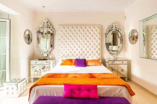 a bedroom with a large bed with purple and orange pillows at Z&Olé in Torremolinos