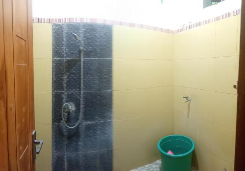 a bathroom with a shower with a bucket in it at Ijen Transito 2 HOMESTAY in Ketapang