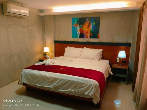 a bedroom with a large bed with a red blanket at La Gensol Plaza Hotel in Mamburao