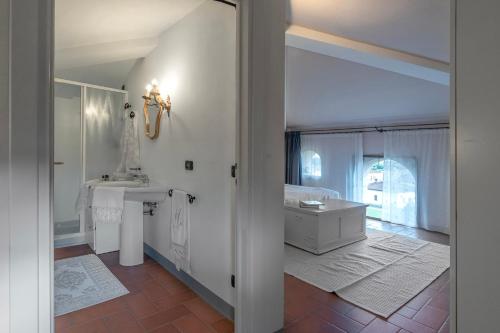 een witte badkamer met een wastafel en een bad bij La Colombaia in Massa e Cozzile