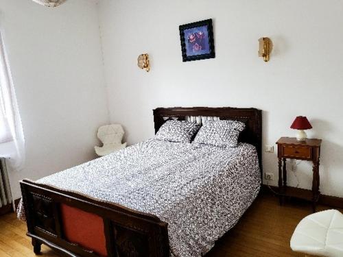 una camera da letto con un letto con un piumone bianco e nero di La maison du village a Encausse-les-Thermes