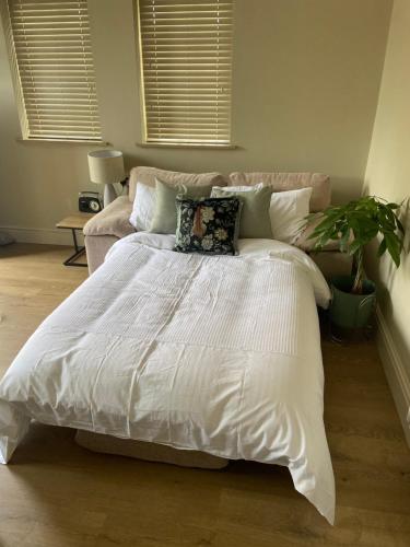 a bed with a white comforter in a bedroom at Cosy small cottage in Wirral Merseyside with kitchen 