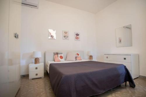 a bedroom with a bed with pink shoes on it at Villetta Aria Prima in Torre Lapillo