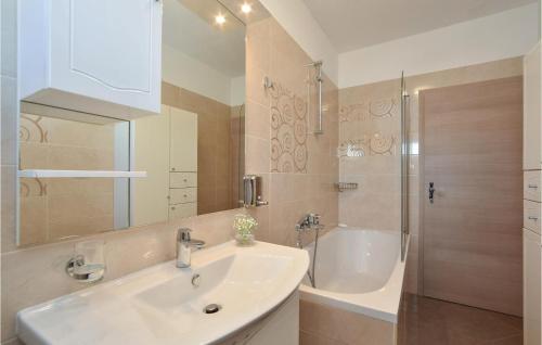 een badkamer met een wastafel, een douche en een bad bij Lovely Home In Split With Jacuzzi in Split