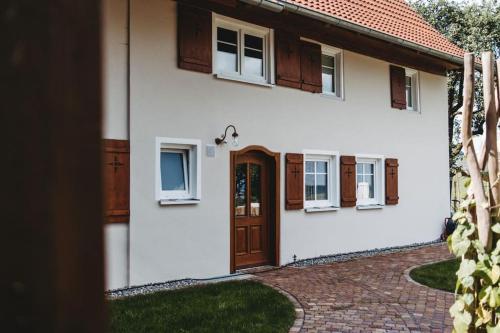 a white house with a brown door and windows at Ferienhof Greuthof in Bad Wurzach