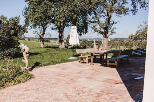 a patio with a table and an umbrella at Ferienhof Greuthof in Bad Wurzach