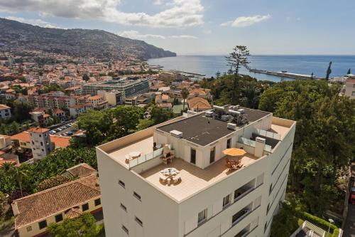 a building with a view of a city and the ocean at Jasmineiro III by An Island Apart in Funchal