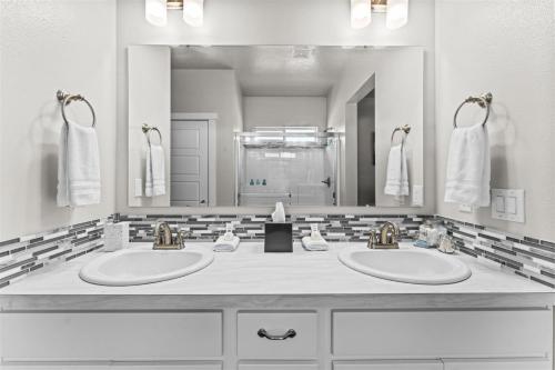 une salle de bain avec deux lavabos et un grand miroir dans l'établissement Adale, à Meridian