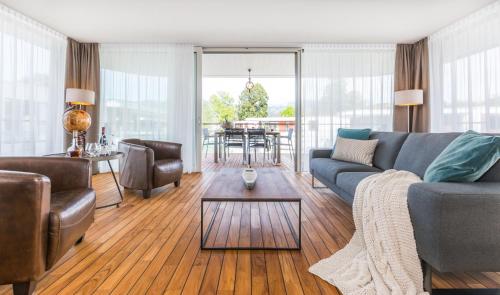 a living room with a couch and a table at Deltapark Vitalresort Seevillen in Thun