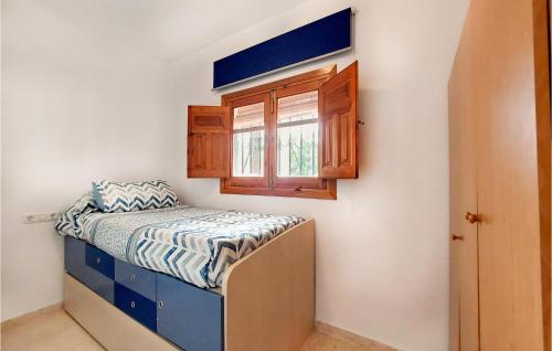 Habitación pequeña con cama y ventana en Amazing Home In El Ventorrillo With Kitchenette, en Belicena