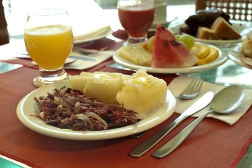 einen Tisch mit zwei Speisen und Getränken in der Unterkunft Pousada Doce Cabana in Porto De Galinhas