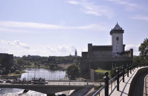 a bridge over a river and a building with a tower at Grafovi Apartments in Narva