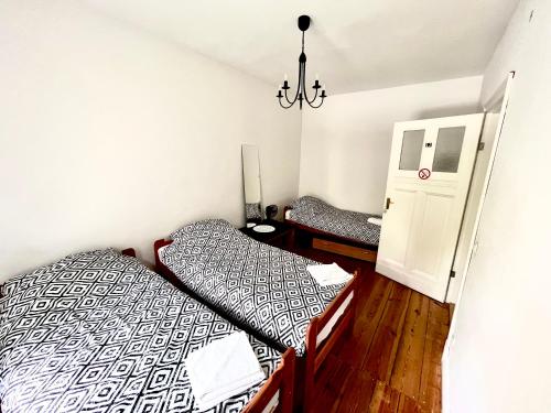 1 dormitorio con 2 camas individuales y lámpara de araña en Agroturystyka Hotel Noclegi Pałac Camping, en Wałcz