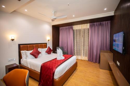 a hotel room with a bed and a tv at Hotel Silver Clé in Hyderabad