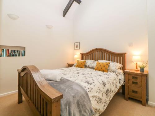 a bedroom with a wooden bed and a night stand at Blackberry Cottage in Kingsbridge