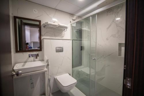 a bathroom with a shower and a toilet and a sink at Hotel Silver Clé in Hyderabad