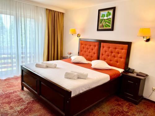 a bedroom with a large bed with two towels at Hotel Piatra Mare in Poiana Brasov