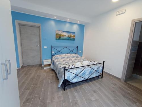 a bedroom with a bed and a blue wall at B&B San Giacomo in Paola