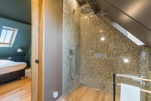uma casa de banho com um chuveiro e uma porta de vidro em Hoeve De Zuidhoek em Bruges