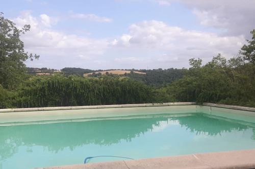 - une piscine bleue avec vue sur les arbres dans l'établissement Villa - Mas de campagne prestigieux- Authentic french countryhouse in dream countryside, à Algans