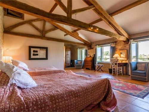 une chambre avec un grand lit dans une pièce avec des plafonds en bois dans l'établissement Villa - Mas de campagne prestigieux- Authentic french countryhouse in dream countryside, à Algans