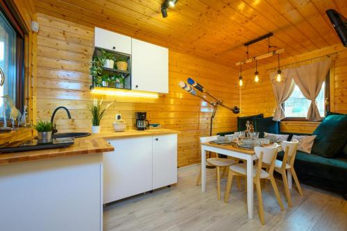 a kitchen and living room with a table and chairs at Zielona Trawa in Bobolin