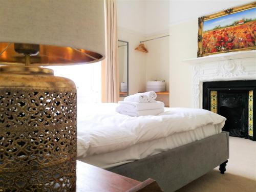 a bedroom with a bed with a fireplace and a lamp at Peaceful & Pretty 2 bedroom flat near Clifton in Bristol