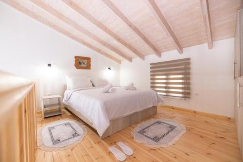 een slaapkamer met een groot wit bed en houten vloeren bij Loft Matina in Nafplio
